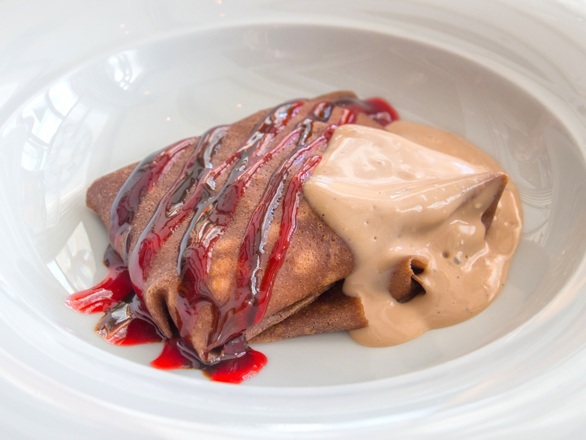 Блинчик с джемом и йогуртом в белой тарелке