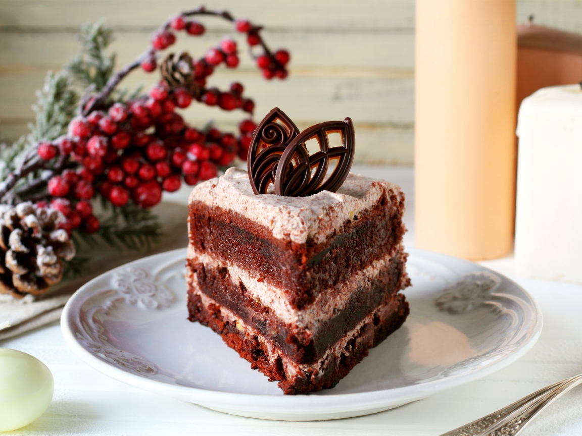 Кусок шоколадного торта на белой тарелке на столе