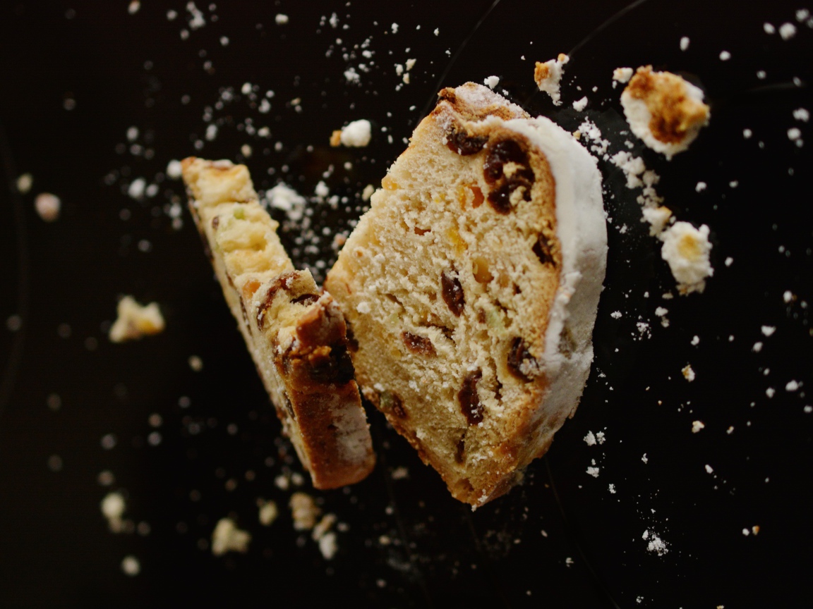 Два куска кекса с изюмом на черном фоне 