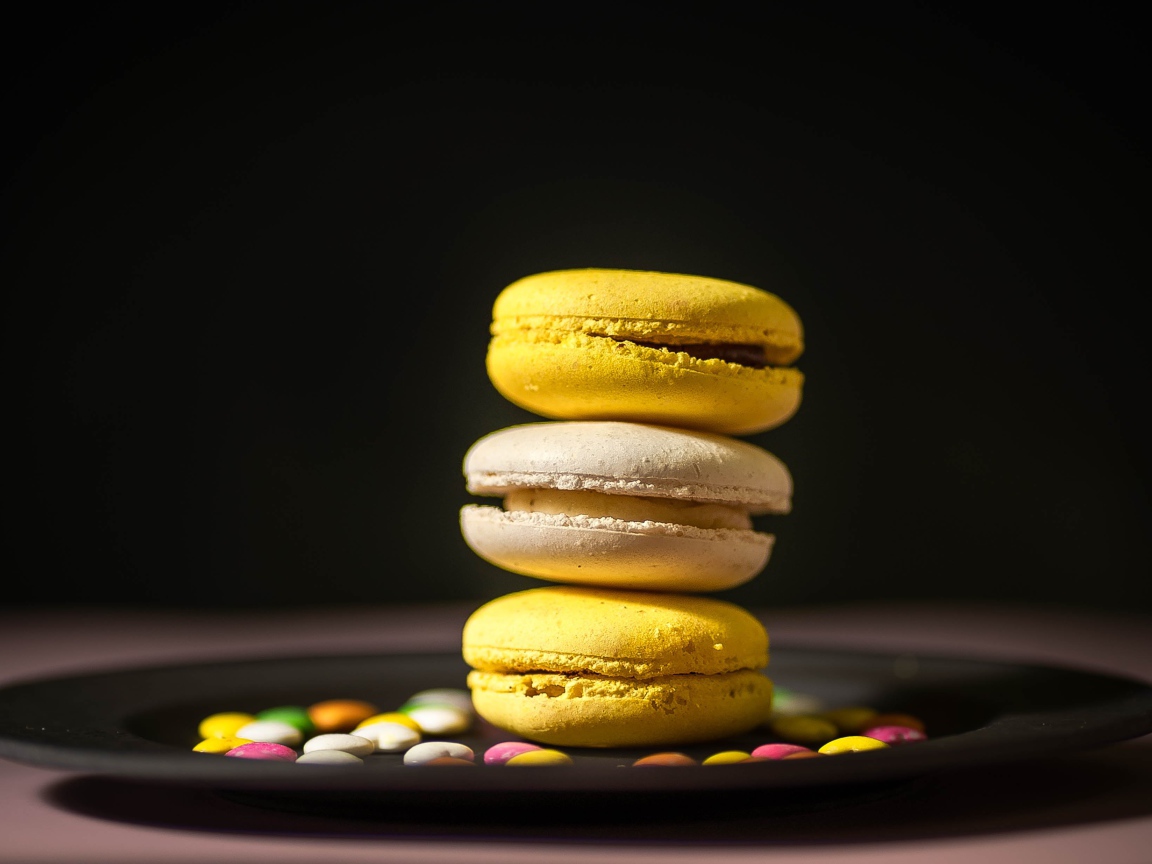 Желтый десерт макарун на тарелке