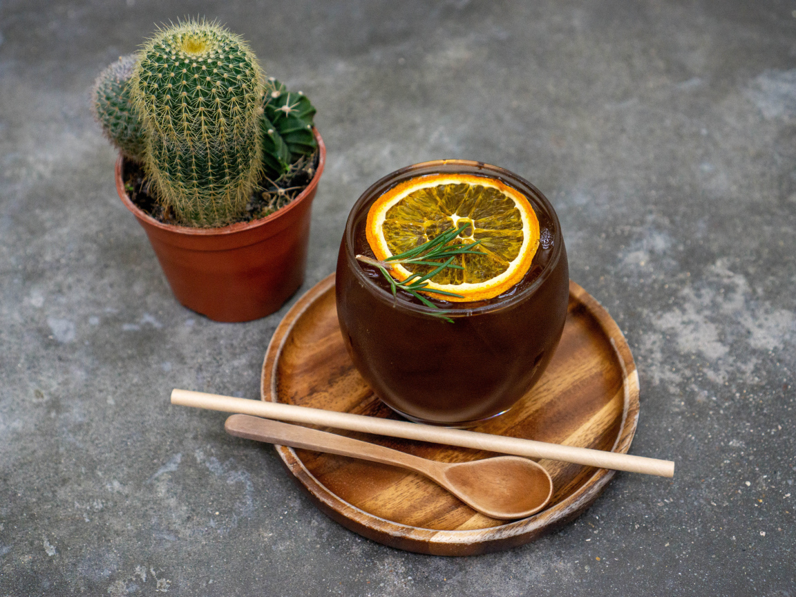 Чай с лимоном на столе с колючим кактусом