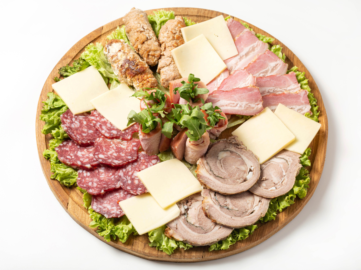 Мясные продукты с сыром на доске на белом фоне