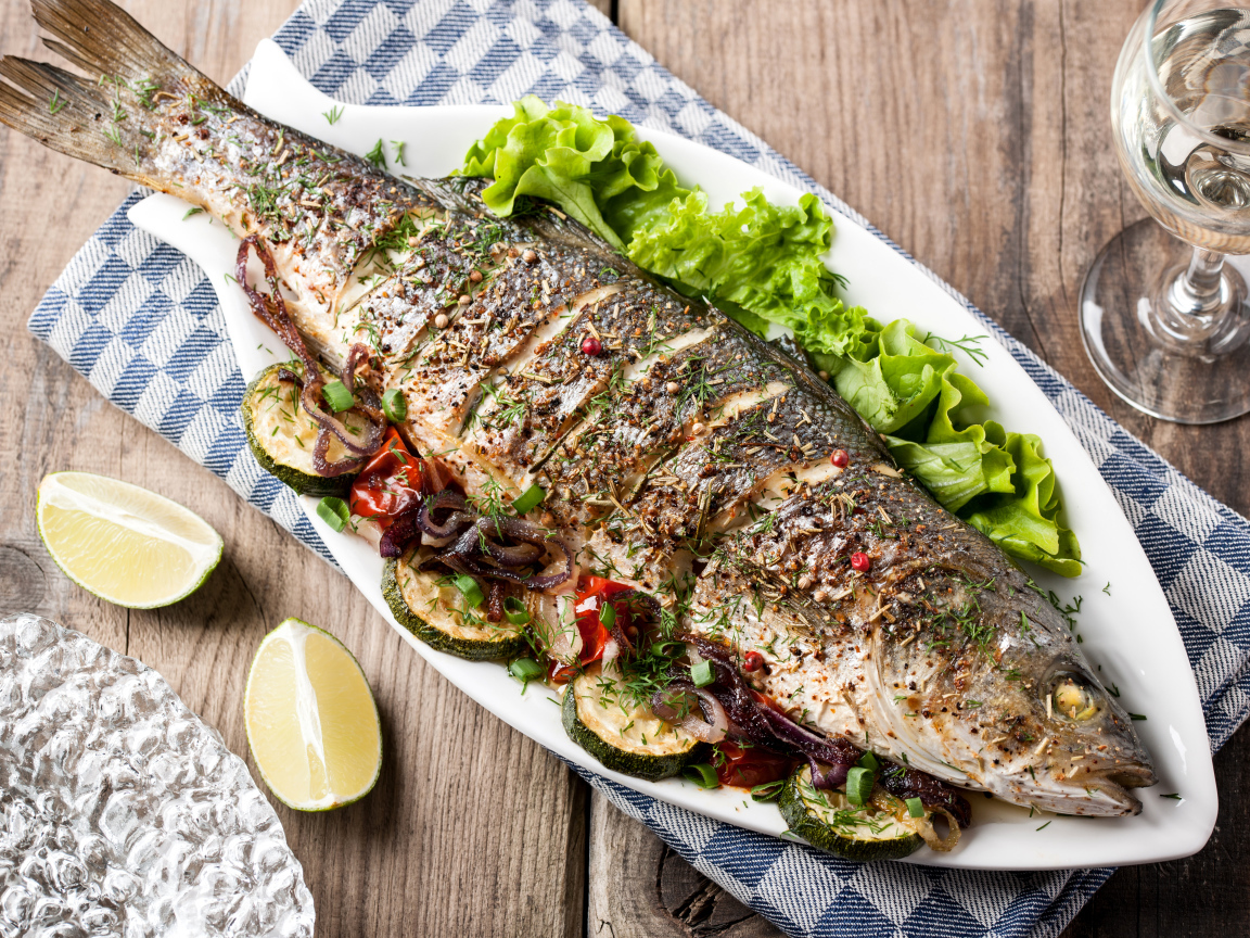 Большая запеченная рыба с кабачками и листьями салата