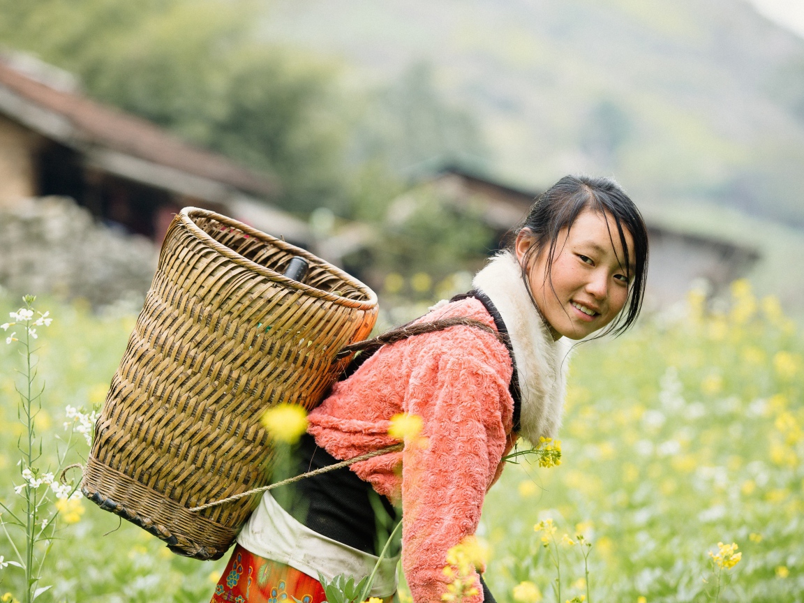 Девушка азиатка с корзиной на поле 
