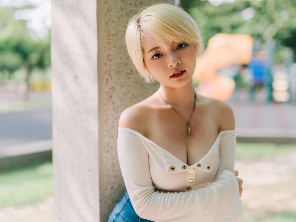 Девушка азиатка с короткой стрижкой у стены 