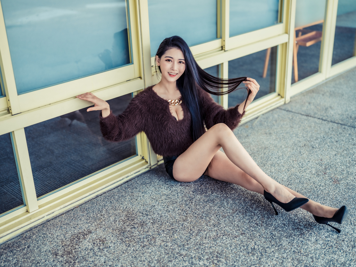 Красивая девушка азиатка в черных туфлях на земле 