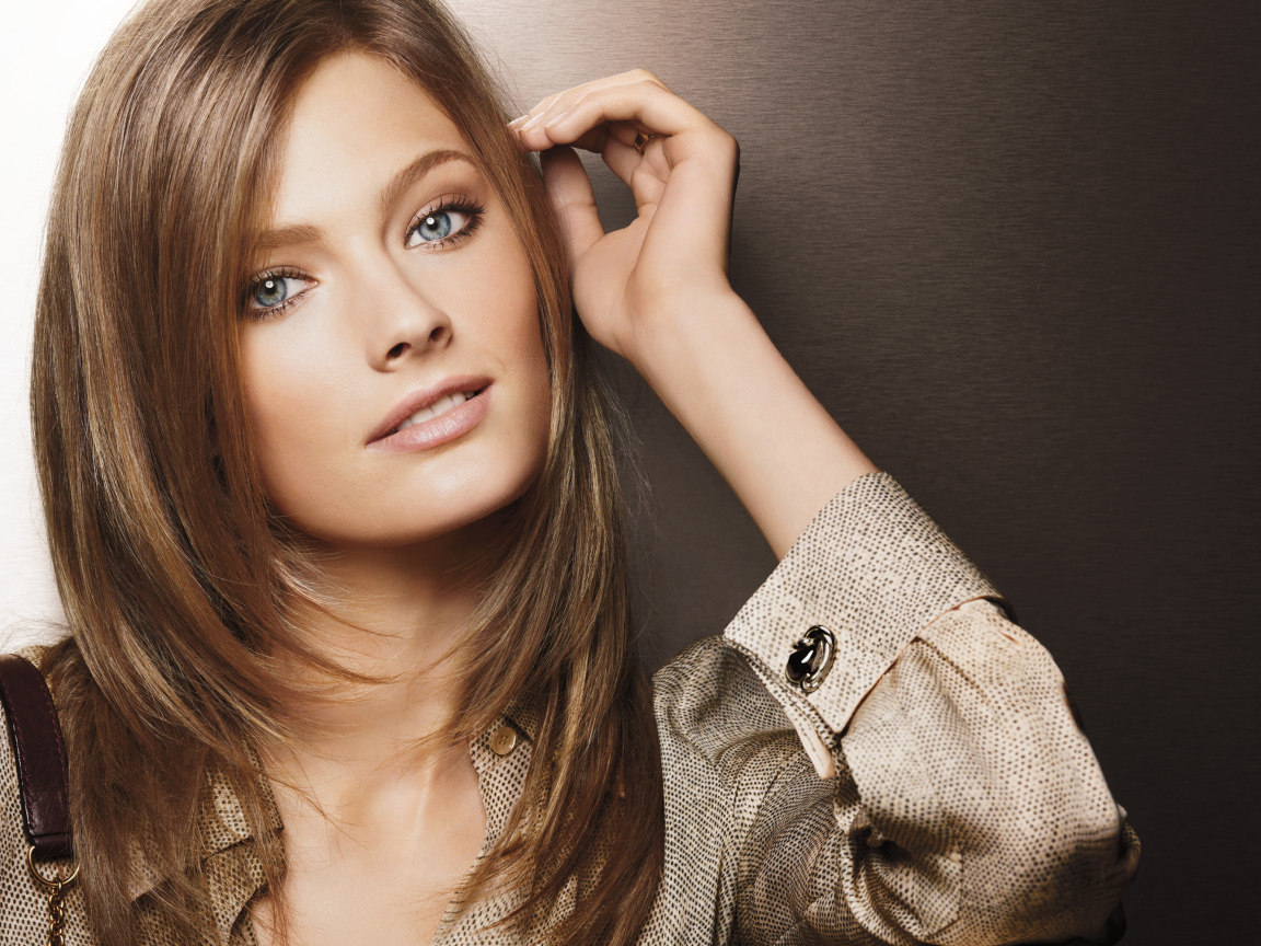 Красивая голубоглазая девушка в рубашке на коричневом фоне 