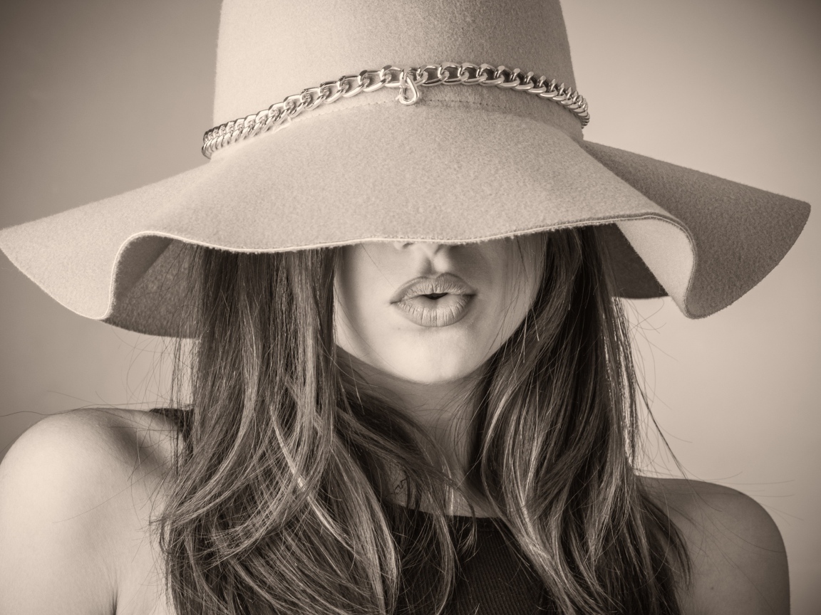 Красивая девушка закрыла лицо шляпой 