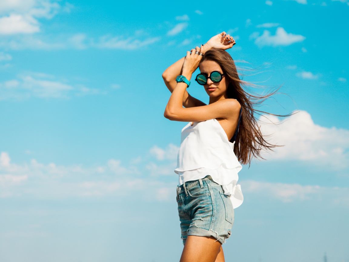 Красивая девушка в шортах на фоне неба