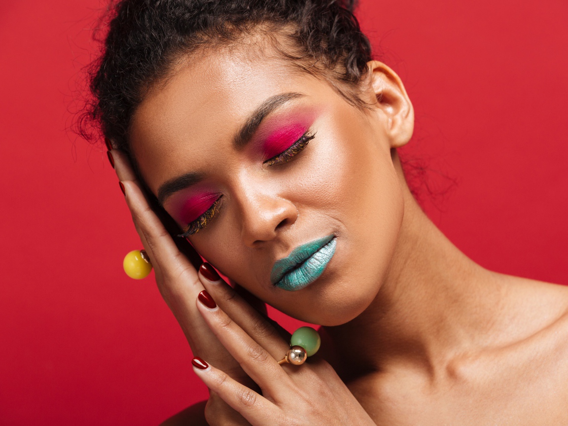 Красивая девушка с ярким макияжем на красном фоне