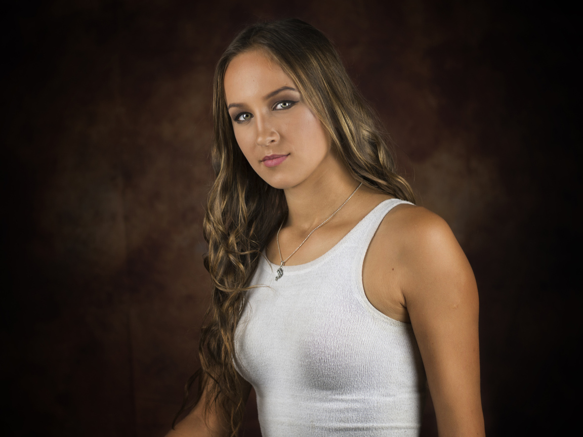 Красивая молодая девушка с длинными волосами в белой майке 