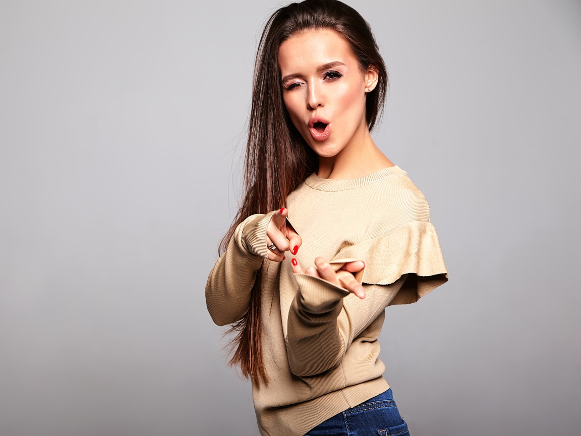 Яркая длинноволосая девушка на сером фоне 