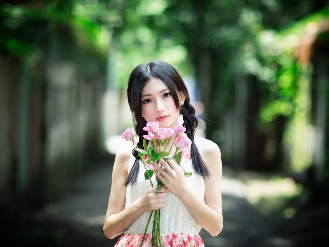 Милая девушка азиатка с букетом розовых роз 