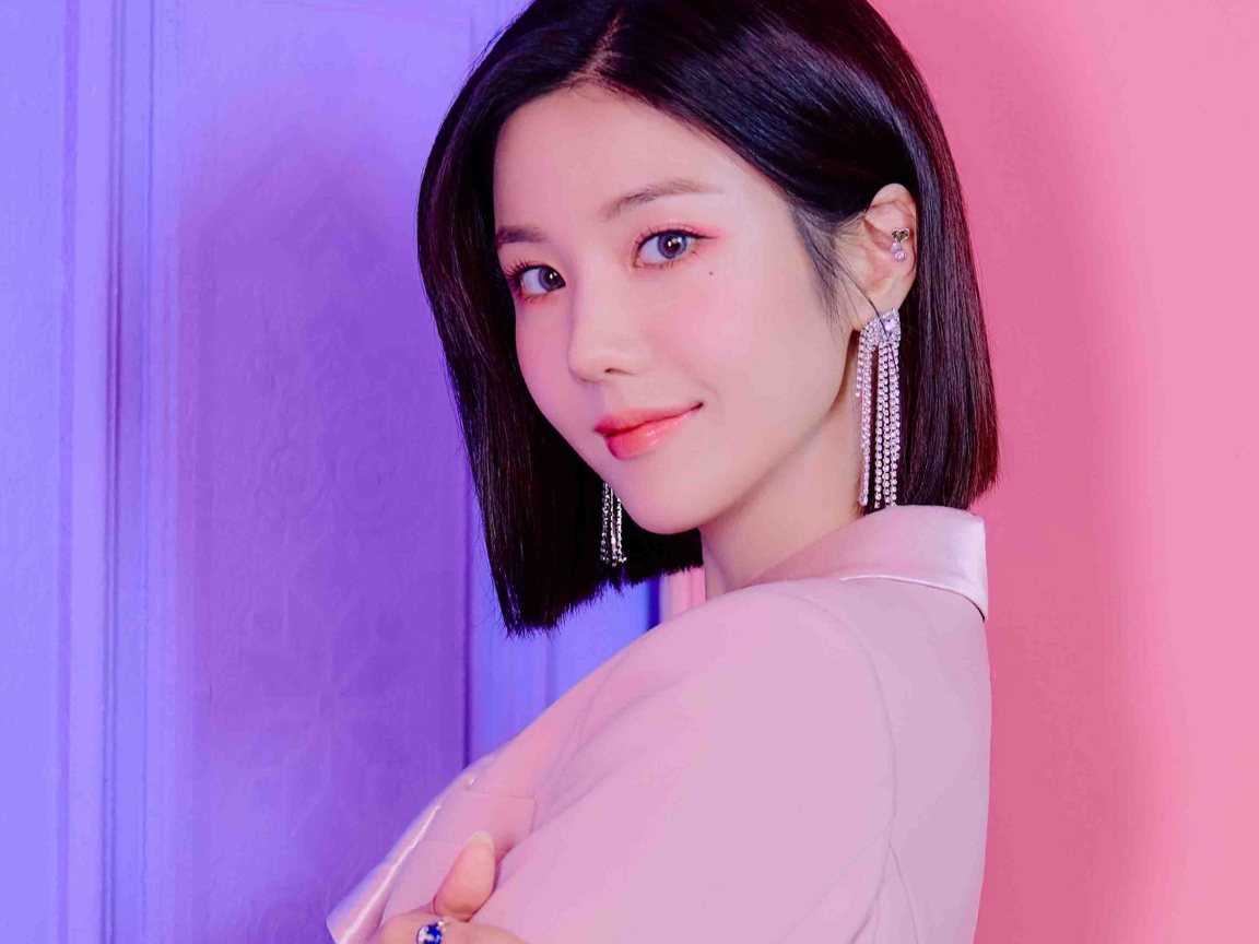 Милая девушка азиатка с короткой стрижкой на розовом фоне 