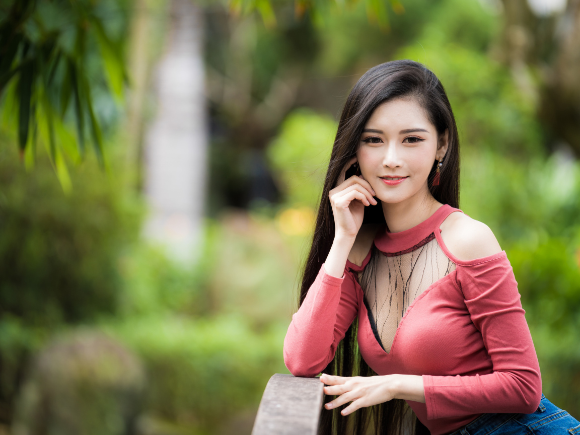 Милая улыбающаяся девушка азиатка розовой кофте