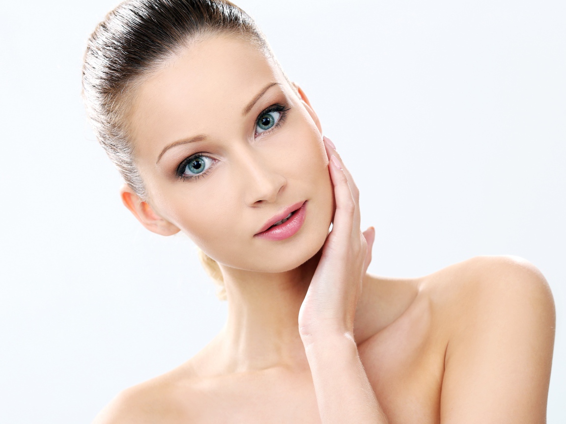 Нежная голубоглазая девушка без макияжа на белом фоне