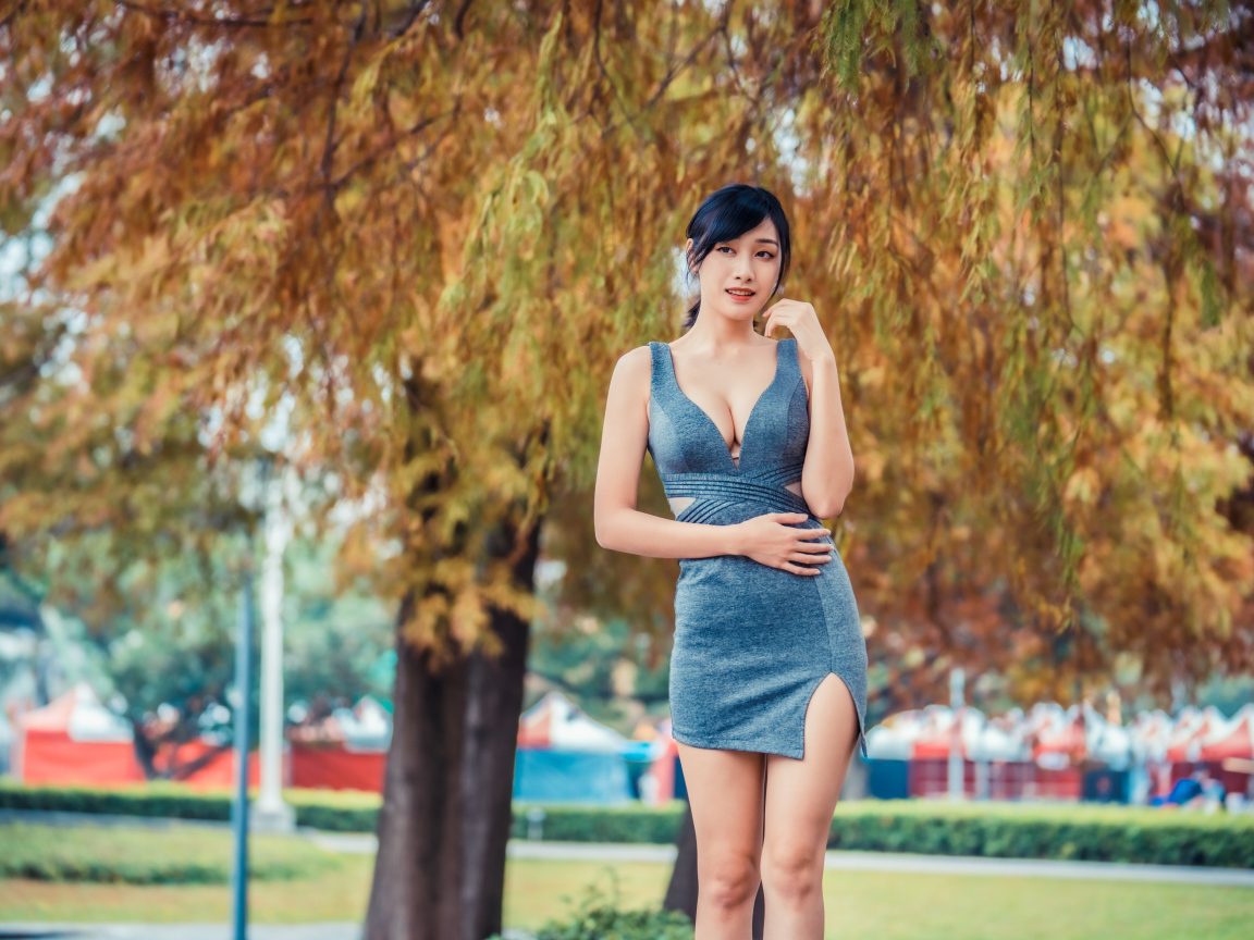 Девушка в сером коротком платье в осеннем парке