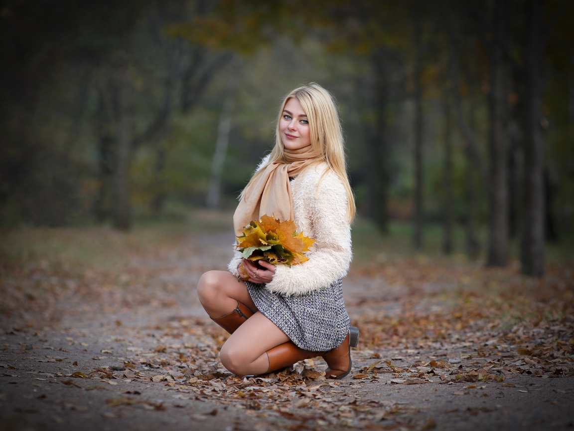 Девушка с листьями на дороге осенью