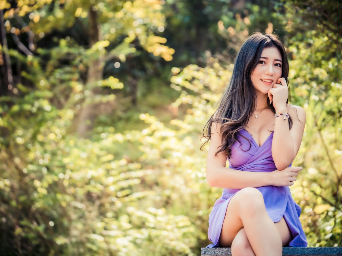 Улыбающаяся девушка азиатка в сиреневом платье