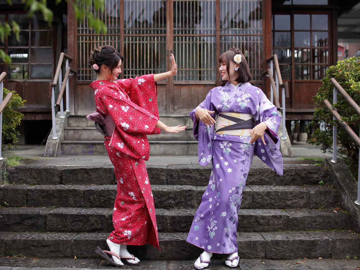 Две красивые девушка азиатки в кимоно на ступеньках