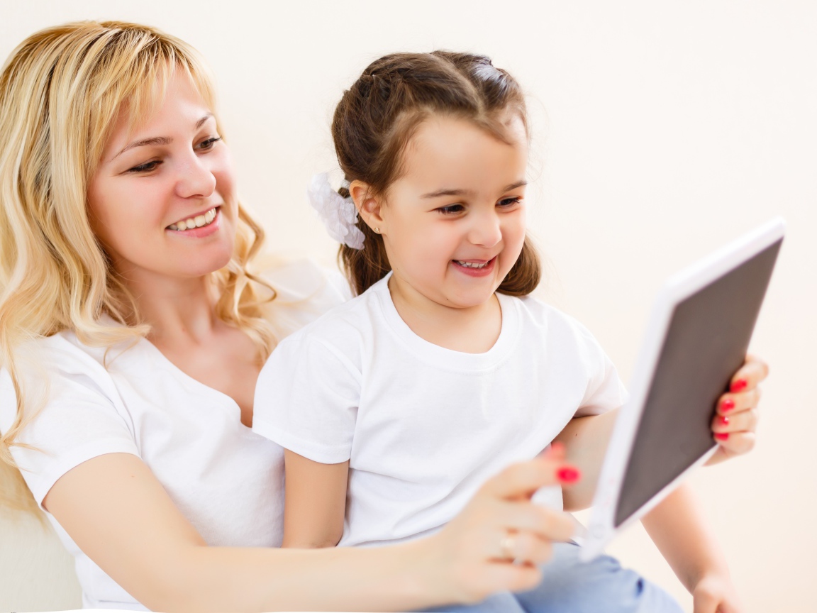 Женщина с маленькой девочкой сидят на  диване