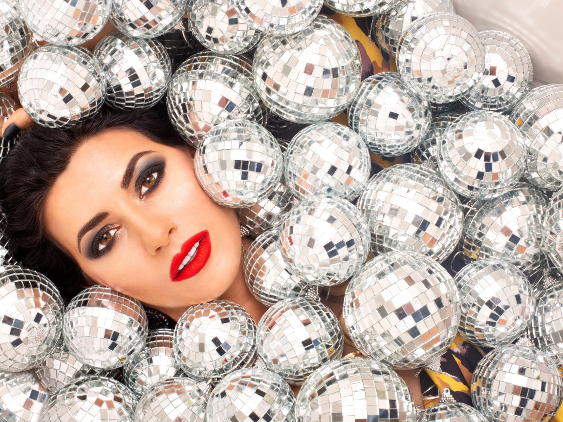 Молодая девушка усыпана блестящими шарами