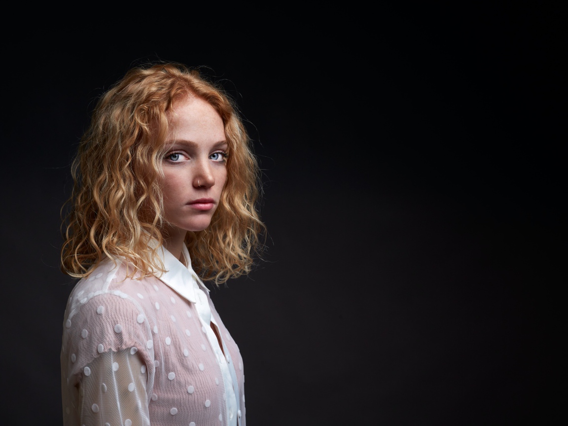 Молодая рыжеволосая девушка на черном фоне