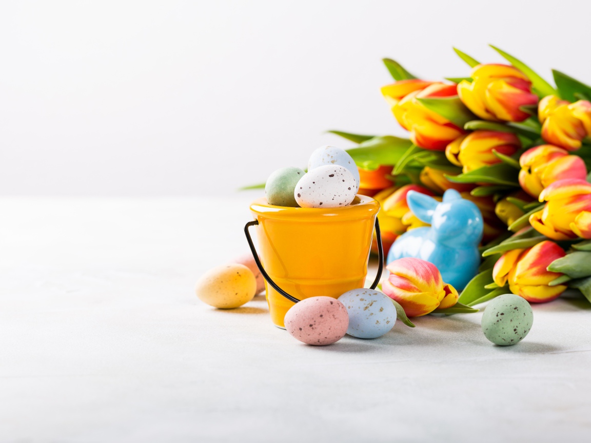 Букет тюльпанов на белом фоне с крашеными яйцами на Пасху