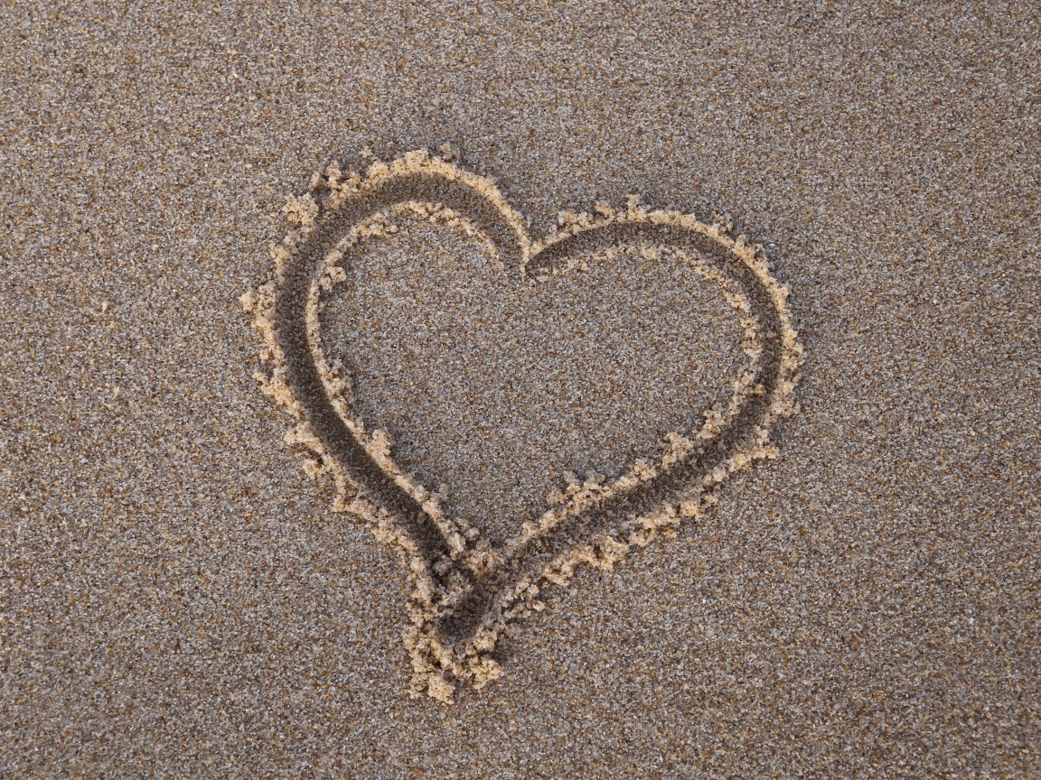 Сердце нарисовано на мокром песке 