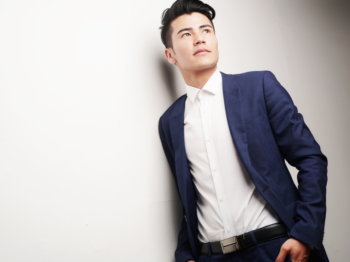 Мужчина модель в костюме у белой стены