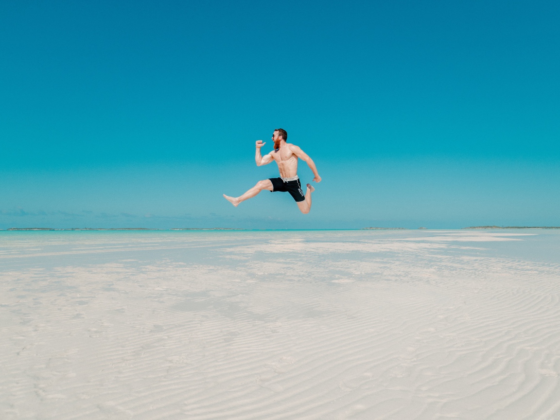 Довольный мужчина прыгает в воде на голубом фоне 