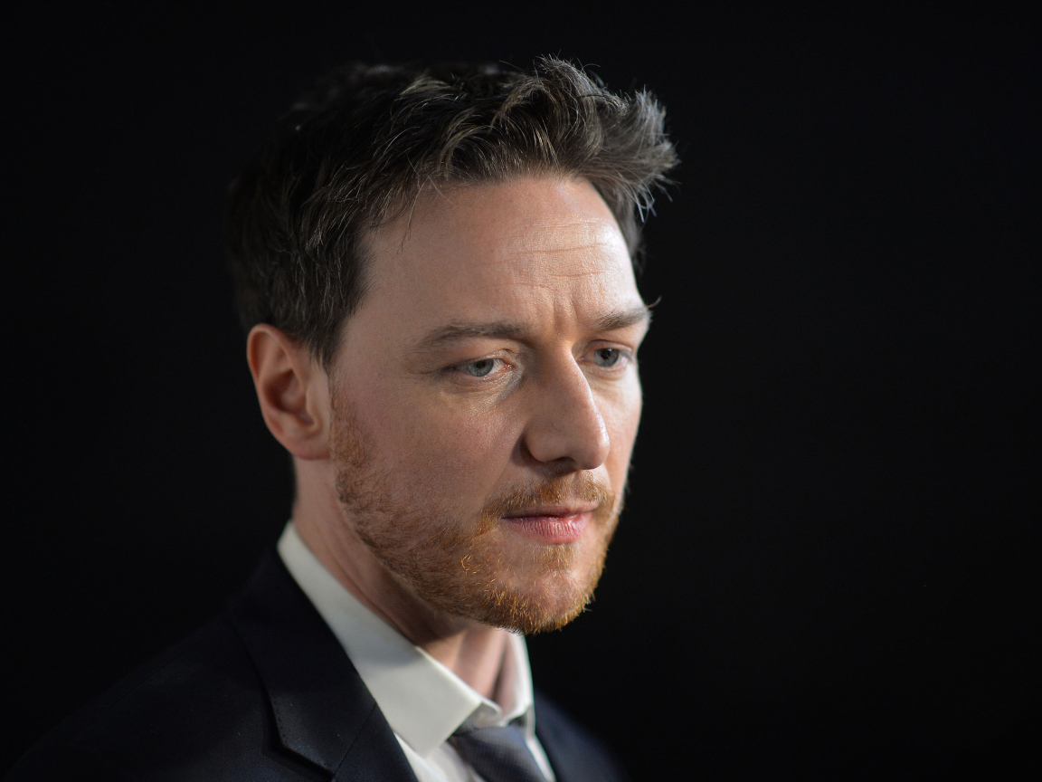 Грустный актер Джеймс МакЭвой на черном фоне