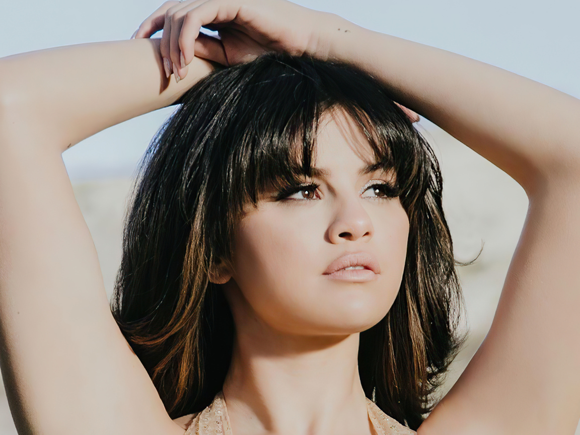 Американская певица Селена Гомес в поднятыми руками