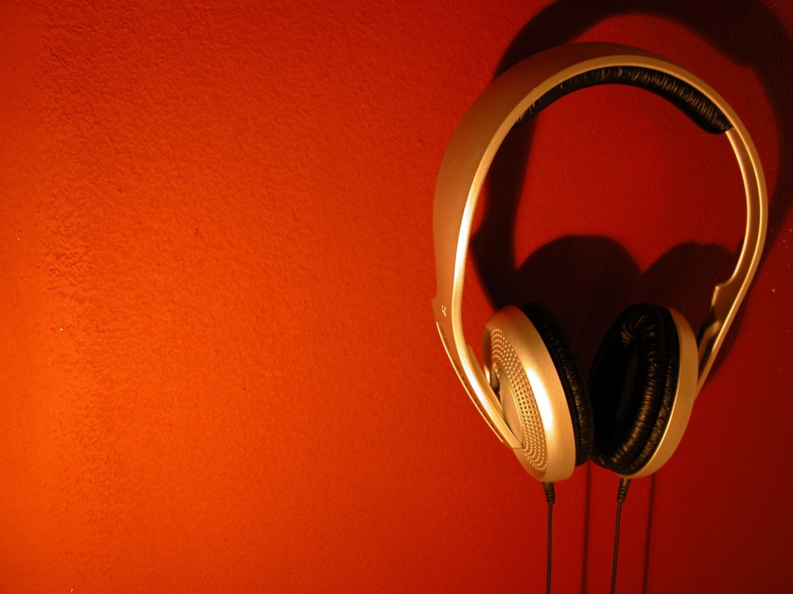Большие золотые наушники на оранжевом фоне 