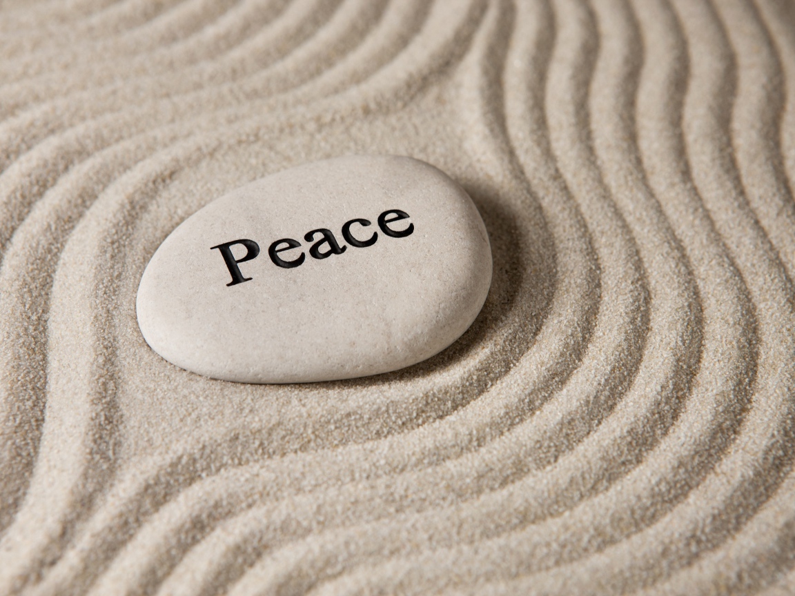 Белый камень с надписью на песке с волнами