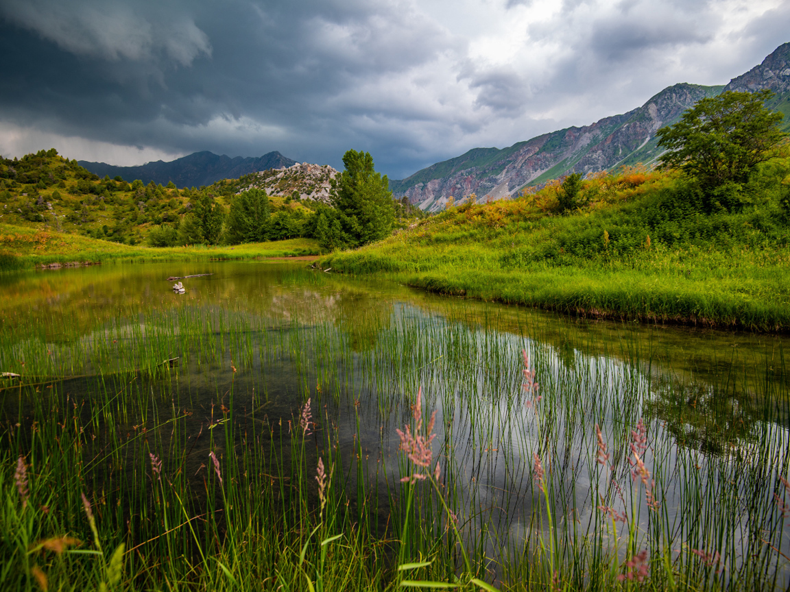 Грозовые облака над рекой в горах 
