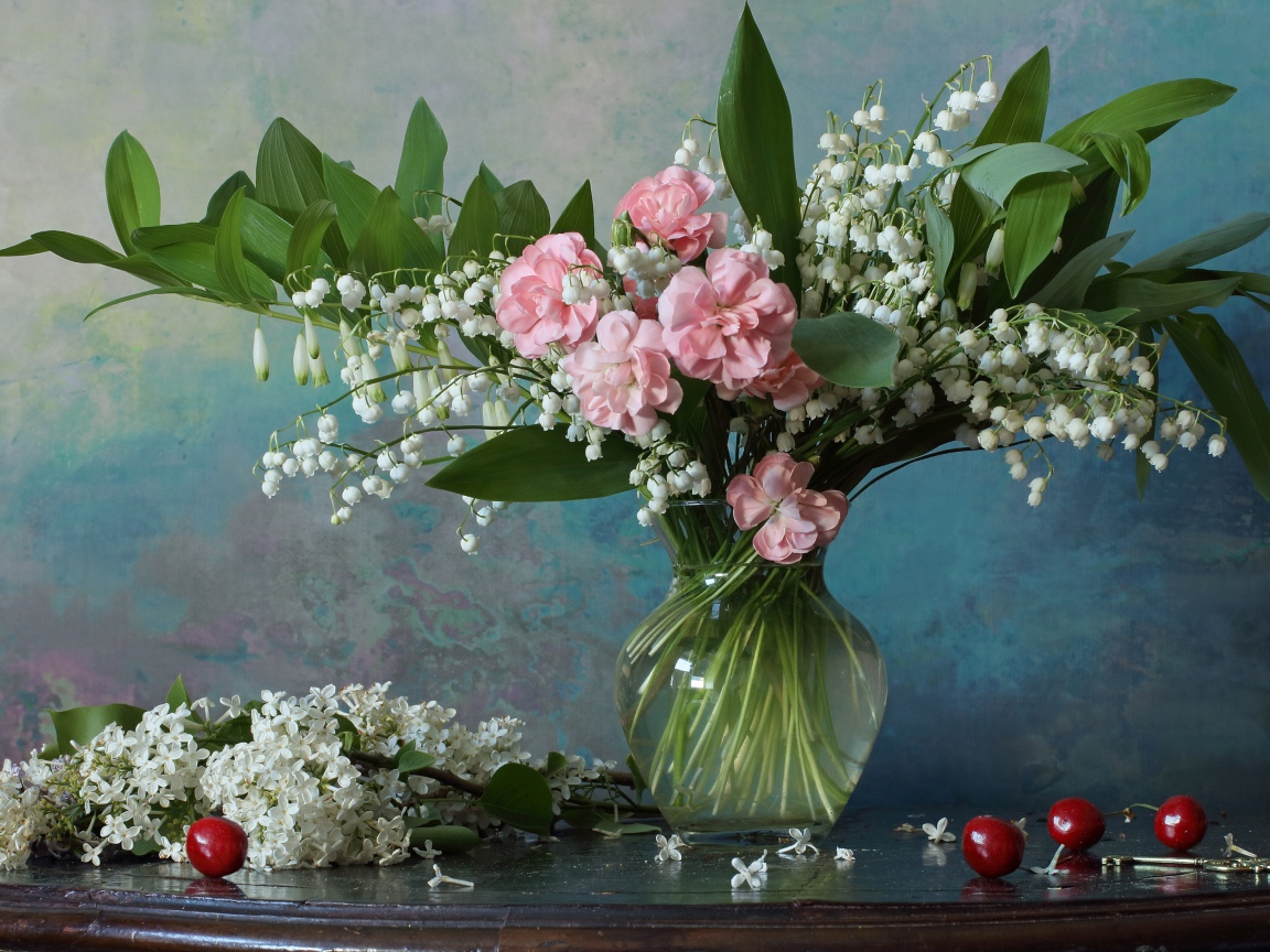 Красивый букет ландышей с розовыми цветами на столе с веткой сирени 