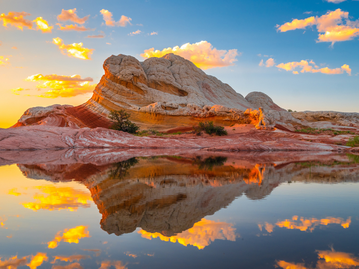 Красивая необычная гора у воды под голубым небом