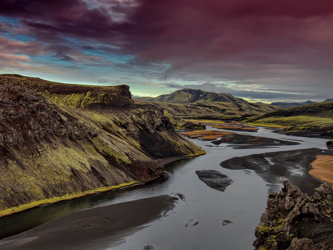 Неглубокая река среди зеленых гор