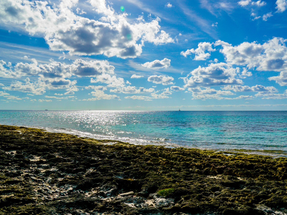 Яркое голубое небо с белыми облаками над морем