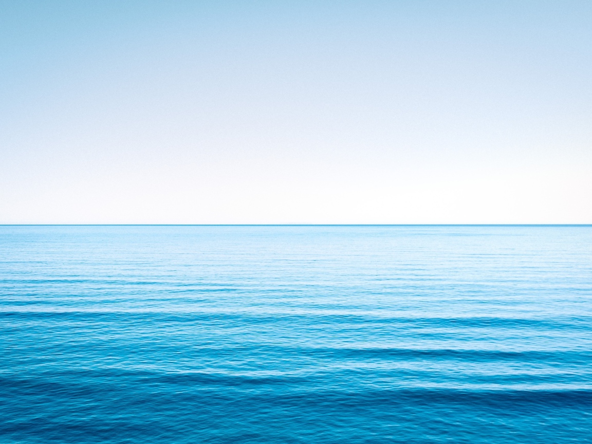 Спокойная голубая морская вода под голубым небом 