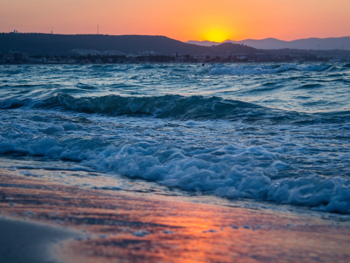 Бушующие волны на берегу моря на закате 