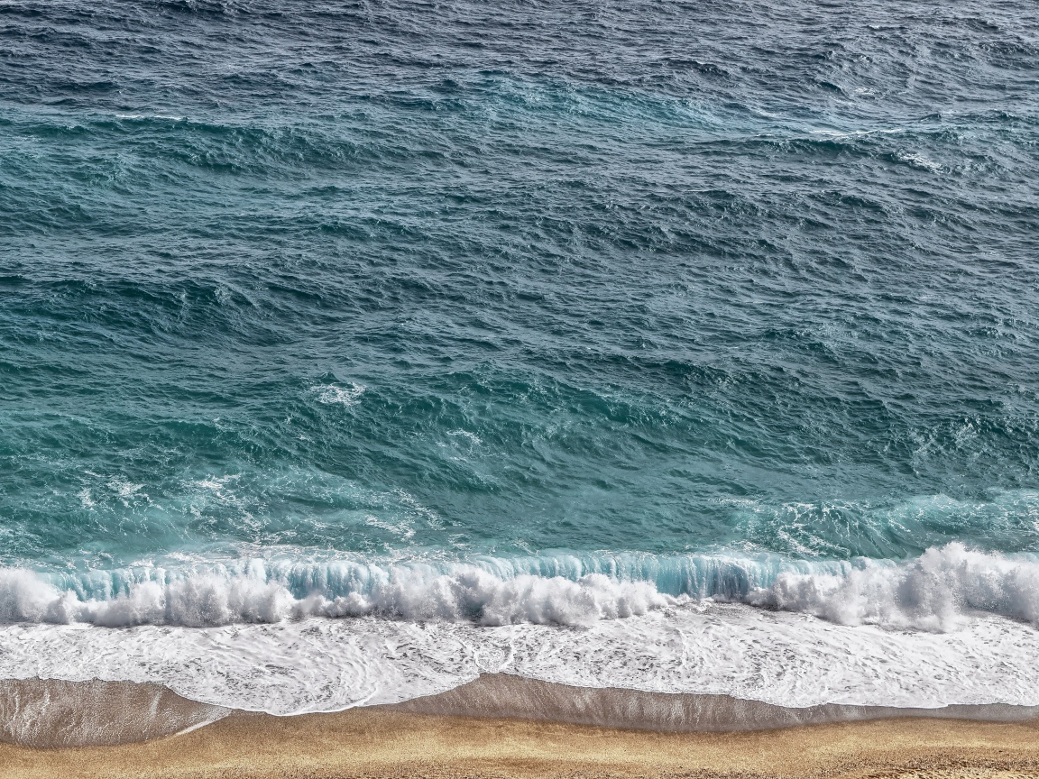 Белая пена от голубой морской воды на песке 