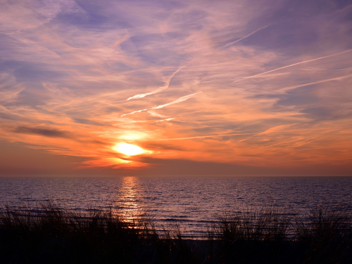 Закат солнца над спокойным озером летом