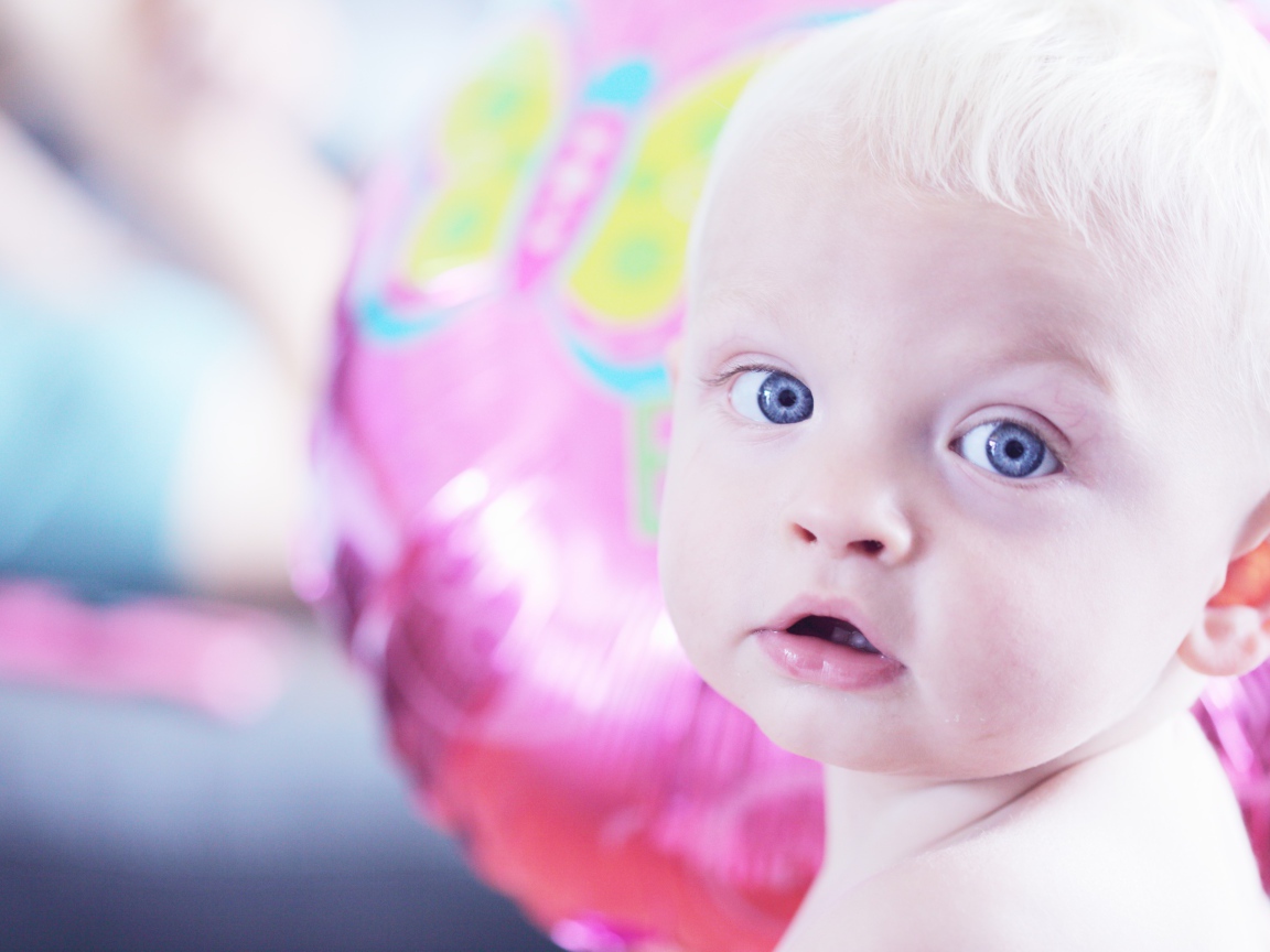 Голубоглазый маленький мальчик на фоне шарика