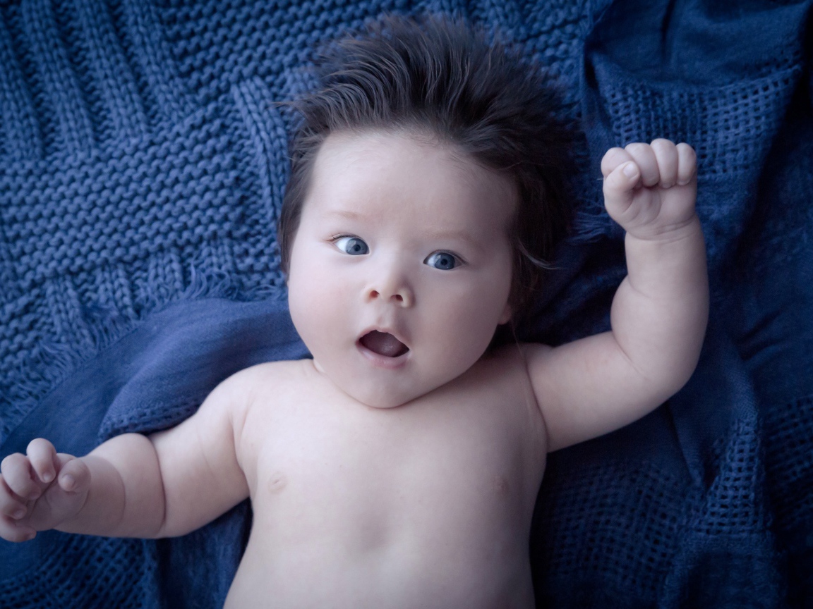 Мальчик с густыми волосами на синем покрывале 