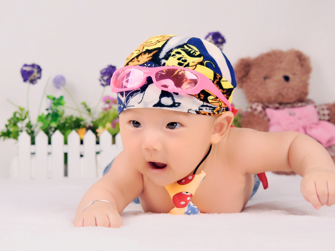 Маленький ребенок азиат в шапке с очками