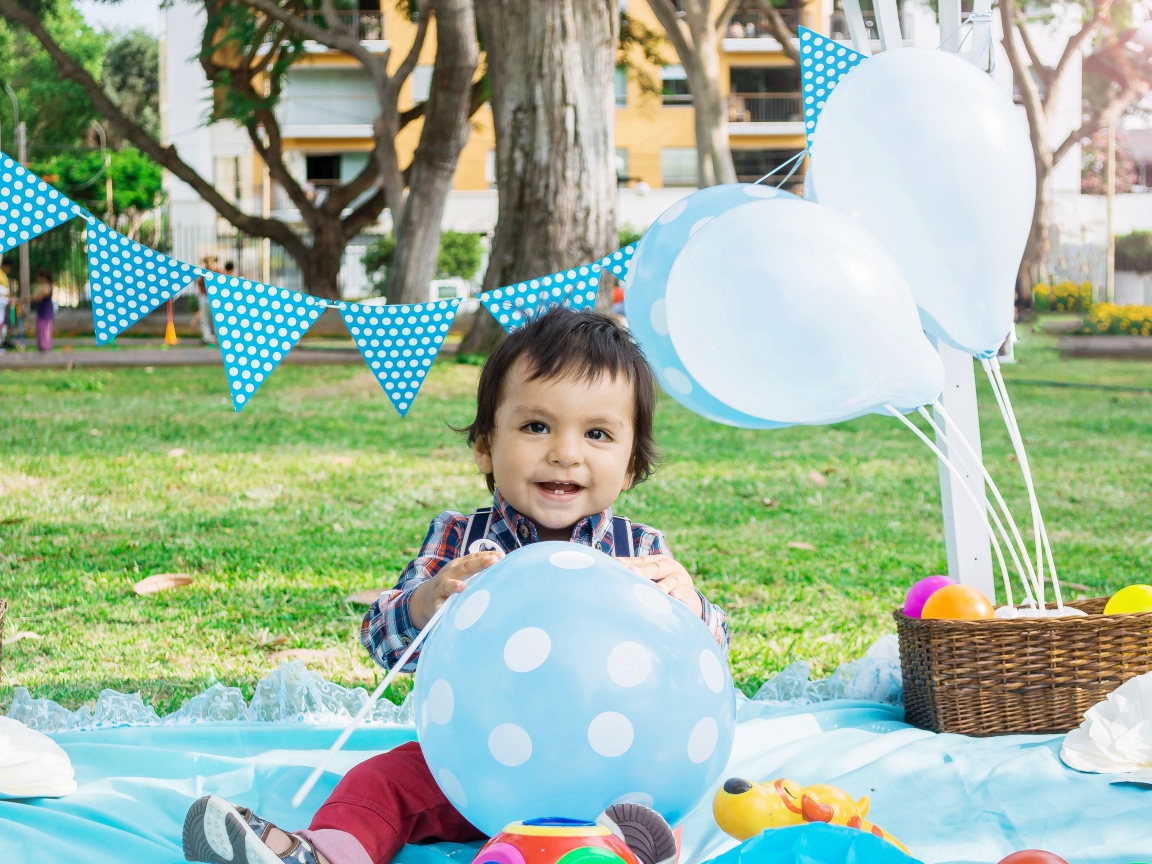 Маленький мальчик с шарами и украшениями на день рождения 