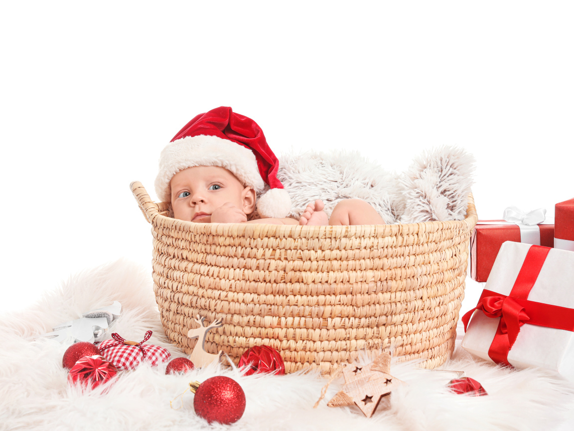 Маленький ребенок лежит в корзине с подарками на новый год
