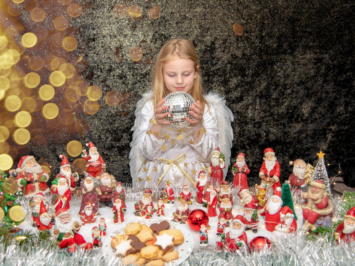 Маленькая девочка в костюме ангела с новогодним декором